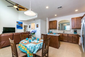 Relax in this inviting living area with a comfortable sofa, dining table, and island.