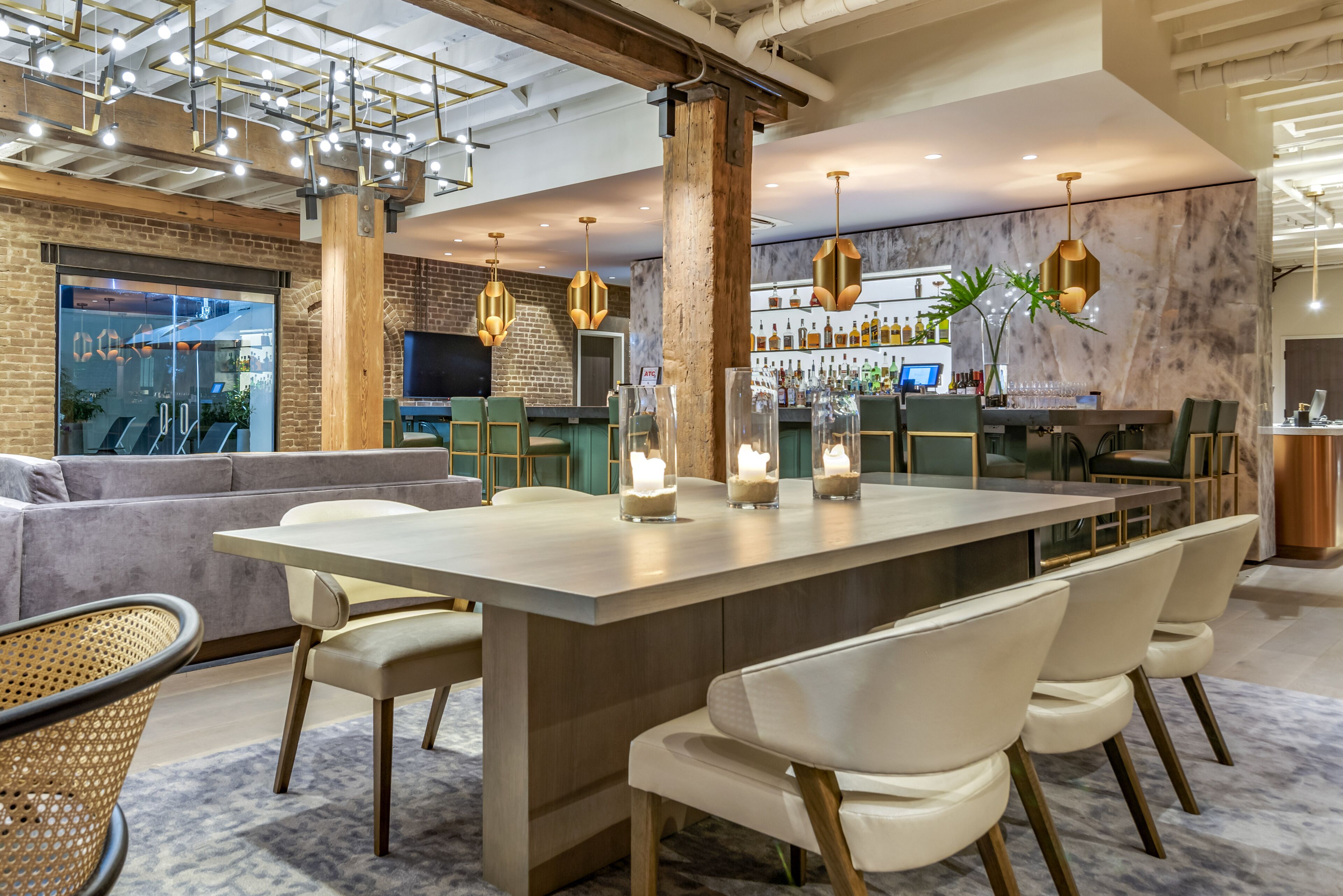 A modern bar area with a long counter, bar stools, and a large screen.