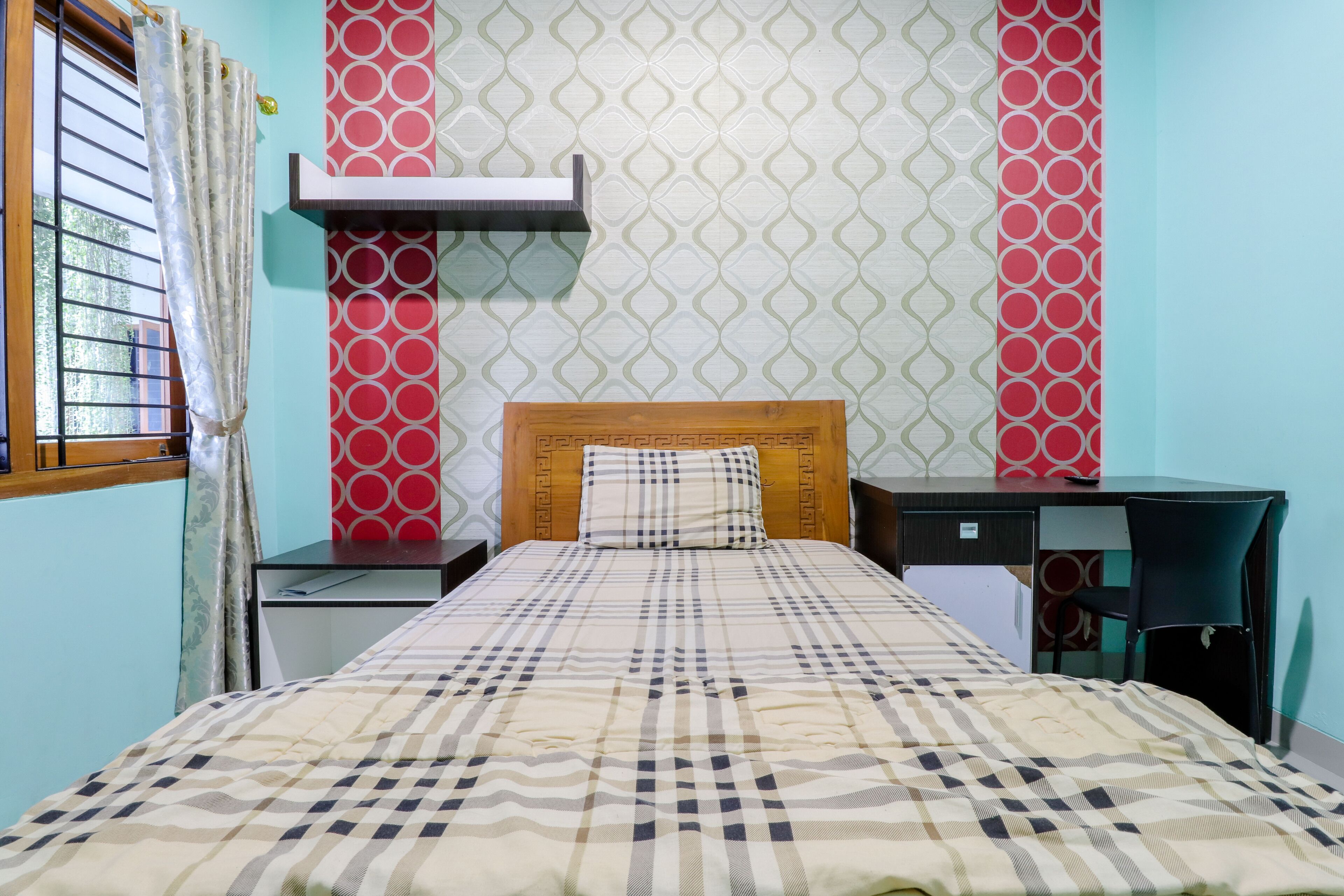 A bedroom with a bed, a desk, and a chair.