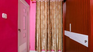 A room with a pink wall, a wooden door, and a curtain. - Khatarina Female Residence - Female Only - khusus wanita (Depok)
