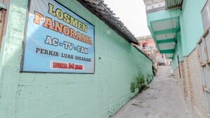 Un callejón estrecho con un letrero que anuncia un programa de televisión.
