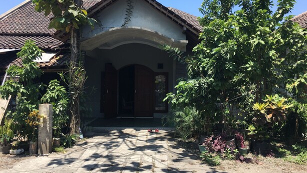 A traditional house with a tiled roof, a porch, and potted plants. - Pak Pur Homestay (Kasihan)