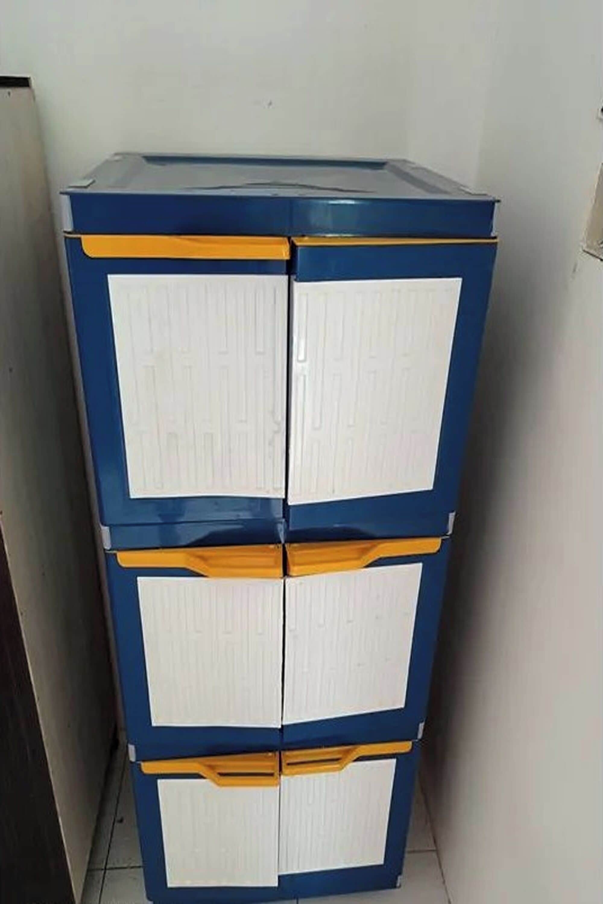 A blue and white storage unit with three drawers and orange handles.