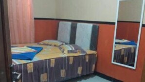 Una stanza piccola e accogliente con un letto singolo, uno specchio e un tavolino.