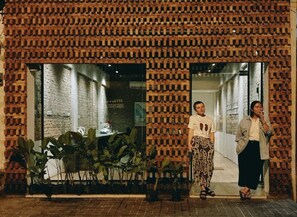 A building facade with a brick pattern and large windows.