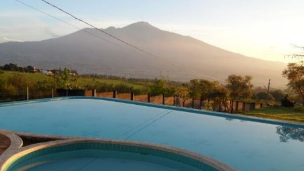 A swimming pool with a view of a mountain in the background. - Villa Panderman View (Batu)