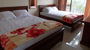A hotel room with two beds, a wooden headboard, a mirror, and a view of greenery through the window. - Villa Panderman View (Batu)