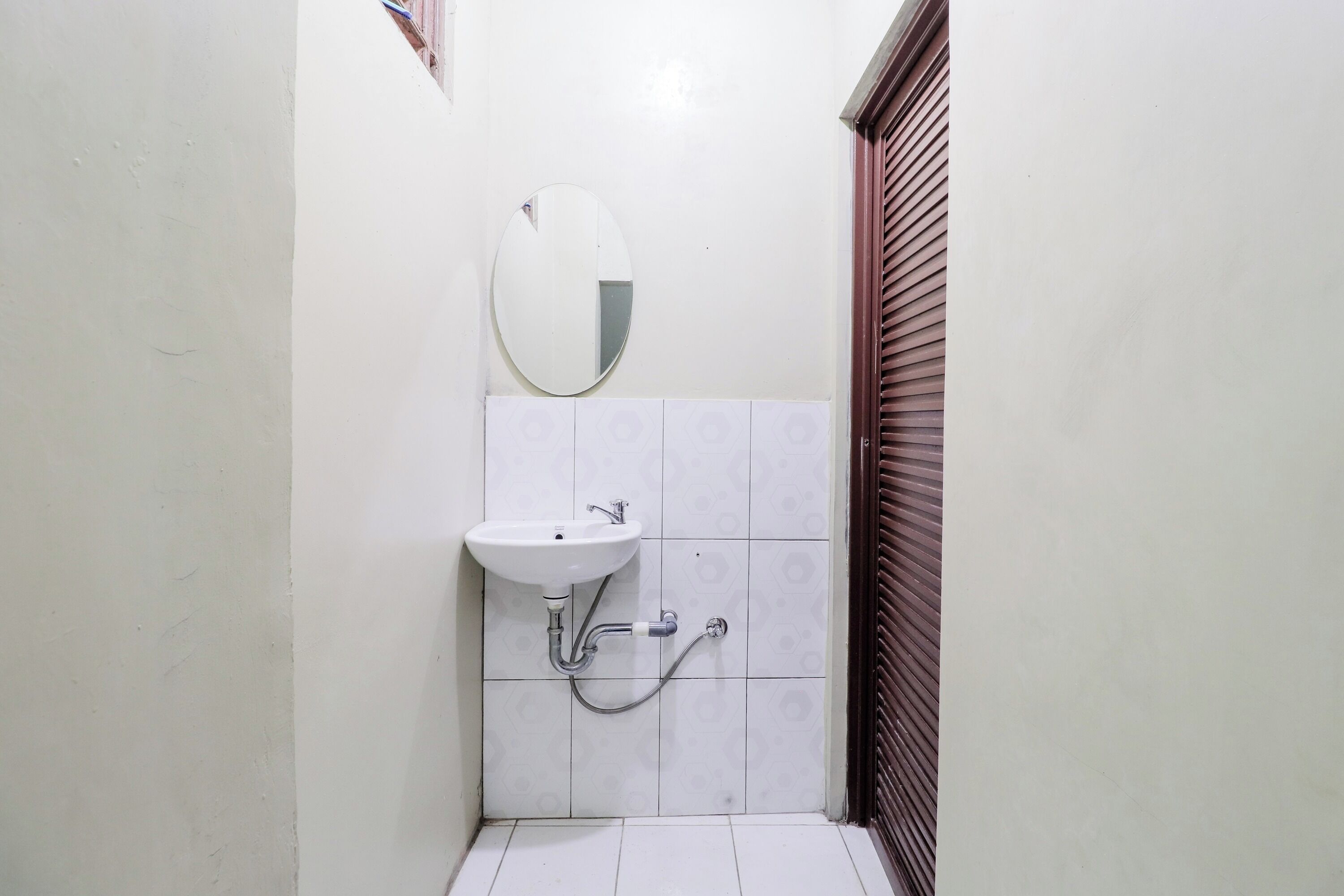 Een kleine badkamer met een wit wastafel, een spiegel en een toilet.