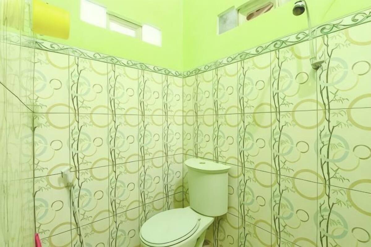 Une salle de bain avec des murs à motifs, des toilettes et un espace douche.