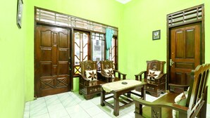 A room with green walls, wooden furniture, and a tiled floor. - Willy Homestay (Borobudur)