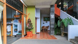 A hotel entrance with a reception desk, a Christmas tree, and a staircase. - deSeruni Guest House (Dalung)