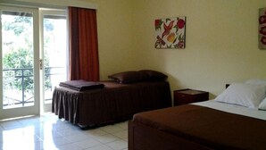 A hotel room with a bed, a nightstand, a wall-mounted air conditioner, a window with curtains, and a balcony. - Rumah Anda Guest House (Bandung)