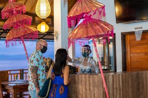 A reception desk with a wooden counter, pink umbrellas, and a sign labeled "OFFICE".