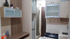 Una cocina compacta con armarios de madera, horno empotrado y refrigerador.