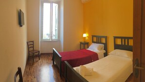 A room with two beds, a chair, a TV, and a window with blinds. - Residence Villa Vittoria B&B (Rome)