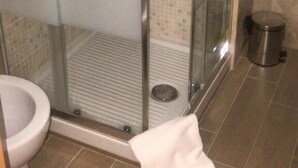 A bathroom with a glass shower enclosure, a toilet, and a trash can. - Residence Villa Vittoria B&B (Rome)