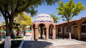 A courtyard with a tiled dome, brick arches, and a playground. - Hotel Santa Rosa (General Cepeda)