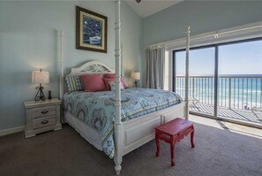 A bedroom with a four-poster bed, a nightstand, a bench, and a large window with a view of the ocean. - DIRECT GULFRONT,2 BALCONIES,3KING BEDS ,GREAT LOCATION  ,GULFRONT POOL (Destin)