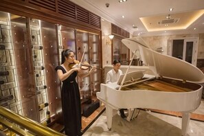 A grand piano in a spacious room with a marble floor and a woman playing the violin. - Samdi Airport Da Nang hotel - 3 minutes to Central (Da Nang)