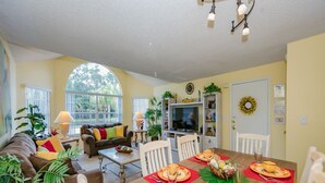 A cozy living room with a dining area, large windows, and a TV. - Royal_palm_bay_99 (Kissimmee)