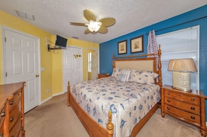 A bedroom with a bed, a nightstand, a dresser, a ceiling fan, and a window with blinds. - Emerald_island_2718 (Kissimmee)