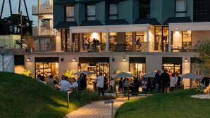 A modern hotel with a geometric facade, outdoor seating area, and a visible entrance. - Campanile PRIME - Rungis Orly (Chevilly-Larue)
