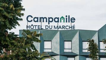 Een modern gebouw met het bordje 'Campanile HOTEL DU MARCHÉ'.