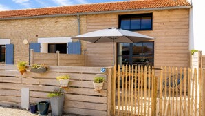 A wooden building with a tiled roof, a wooden fence, and potted plants. - LE STUDIO, Gîte 3. Clos des Aigrettes,  30m from La Cotiniere Port (Saint-Pierre-d'Oléron)