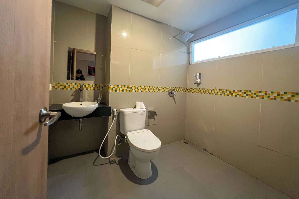 A bathroom with a toilet, sink, and shower.