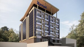 A modern hotel building with a flat roof, multiple balconies, and a prominent sign reading "Kyriad Hotel". - Kyriad Haka Makassar (Makassar)