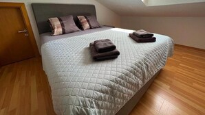 Une chambre à coucher avec un lit, des oreillers et des serviettes pliées.