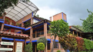 A hotel with a reception area, multiple balconies, and a brick facade. - Hotel Zaragoza Tepoztlan (Tepoztlán)