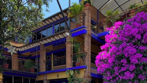 A pool area with lounge chairs, a swimming pool with a turtle design, and a building with balconies and potted plants. - Hotel Zaragoza Tepoztlan (Tepoztlán)