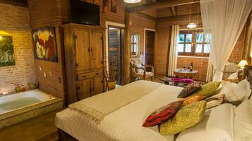 Una habitación rústica con una cama grande, un armario de madera, un televisor y una ventana con cortinas.