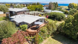 A residential area with houses, a patio with outdoor furniture, and a view of the sea.