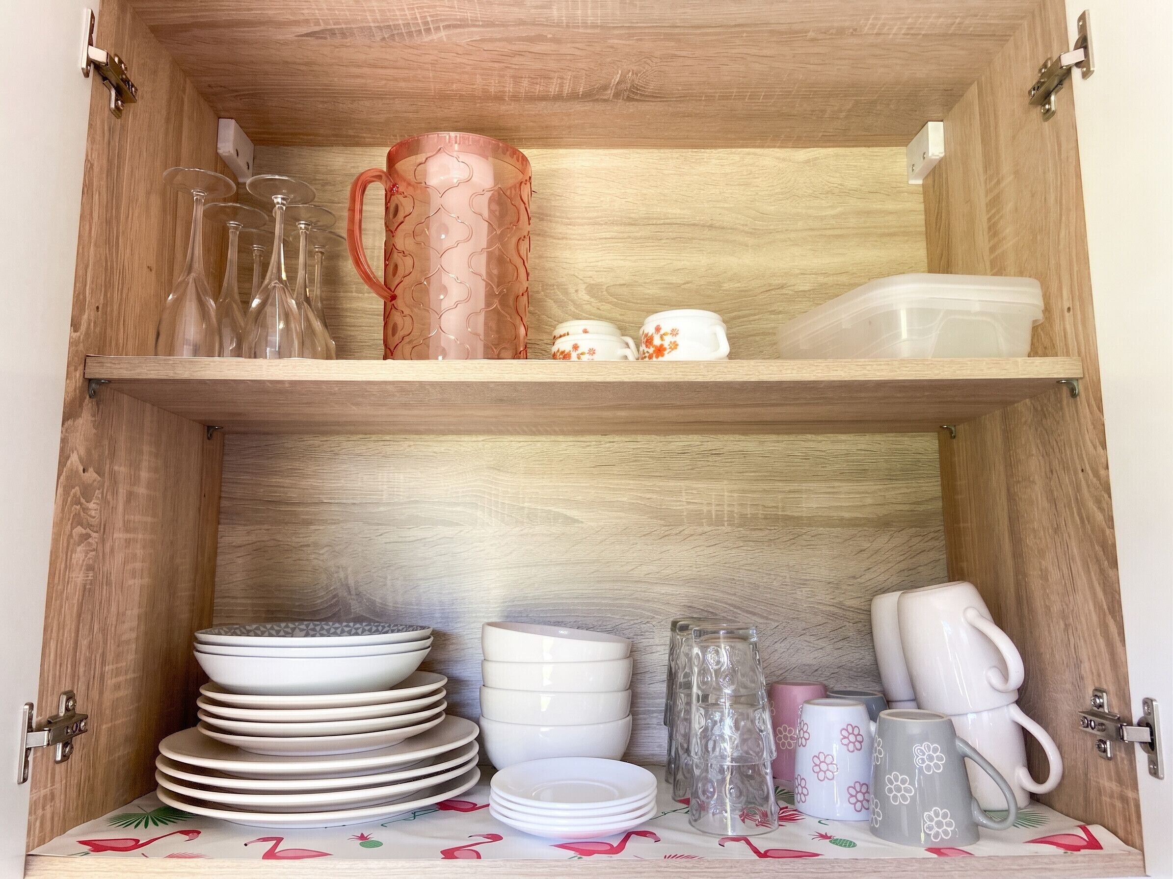 A wooden cabinet with shelves holding various kitchenware items.