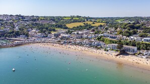An aerial view of a coastal town with a beach, houses, and a marked area named "Mermaid Appt."