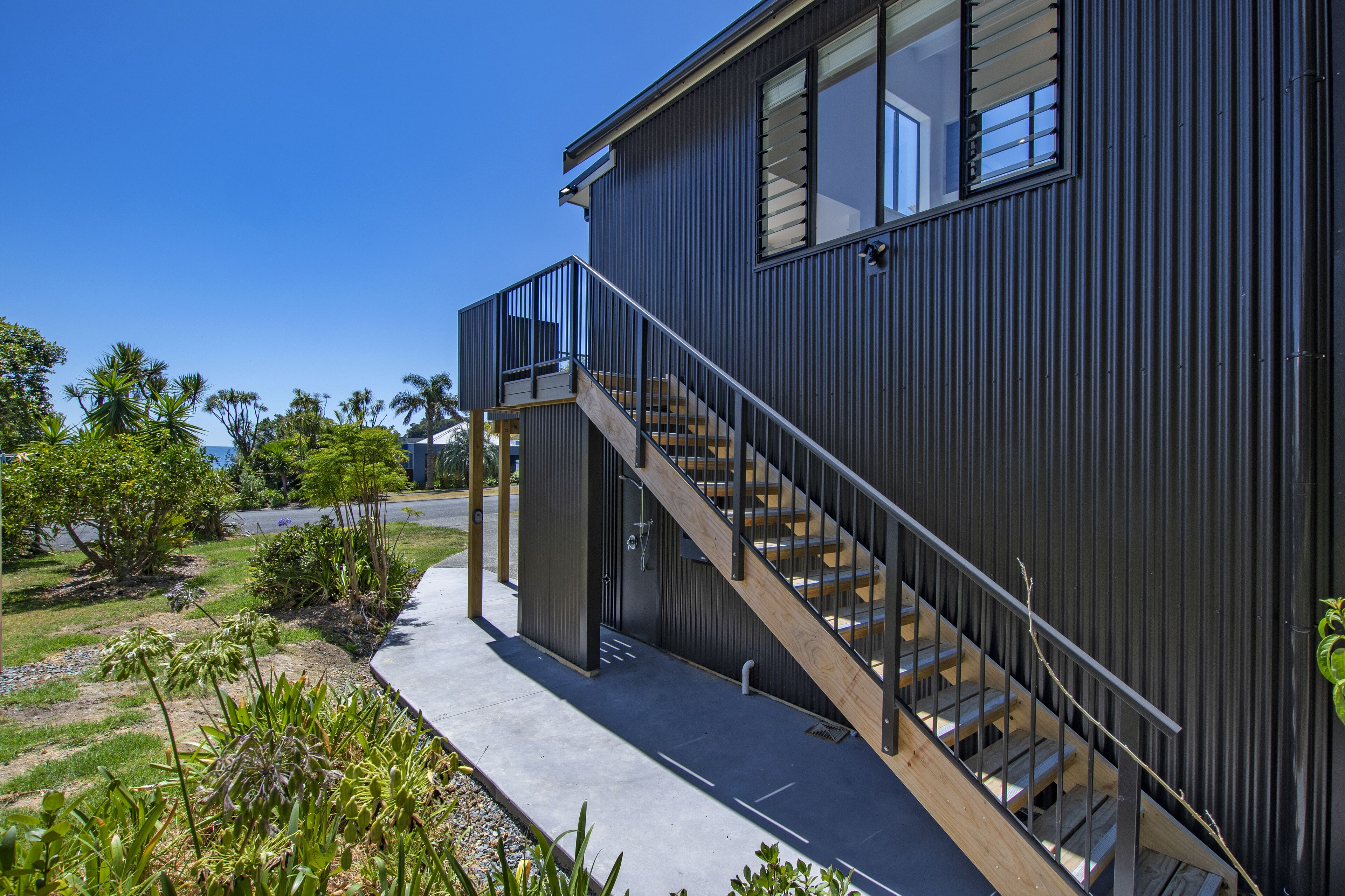 A modern building with a wooden staircase leading to a balcony.