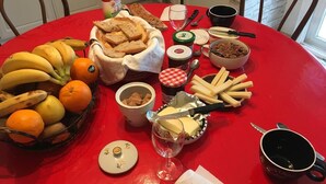 A table with a variety of food items including bread, cheese, and fruits. - Paradis la Provence entre Vienne et Lyon (Saint-Cyr-sur-le-Rhône)