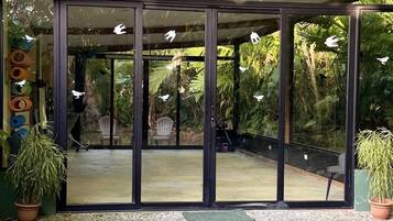 A modern building with large glass doors and a gravel ground.