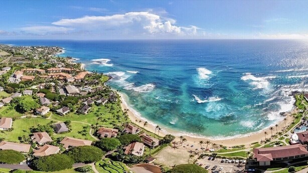 An aerial view of a coastal area with houses, a beach, and the ocean. - KIAHUNA BEACH HOUSE #50 NEW REMODEL GROUND FLOOR NEW AC TWIN BRIDGES GARDEN VIEW (Koloa)
