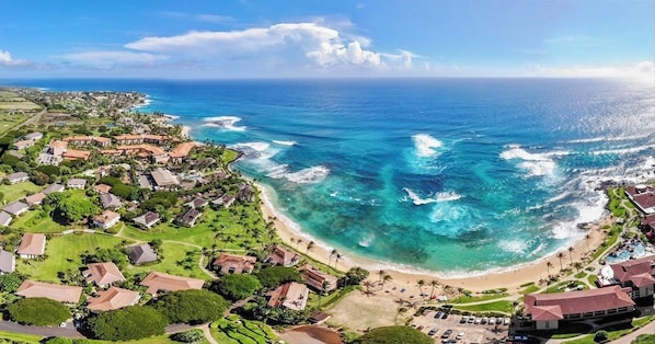Vista aérea de una zona costera con casas, una playa y el océano.