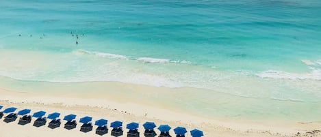 On the beach, white sand, sun-loungers, beach umbrellas