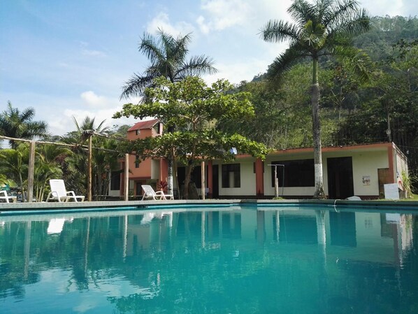 حمّام سباحة خارجي، مظلات على حمّام السباحة، مقاعد للتشمس