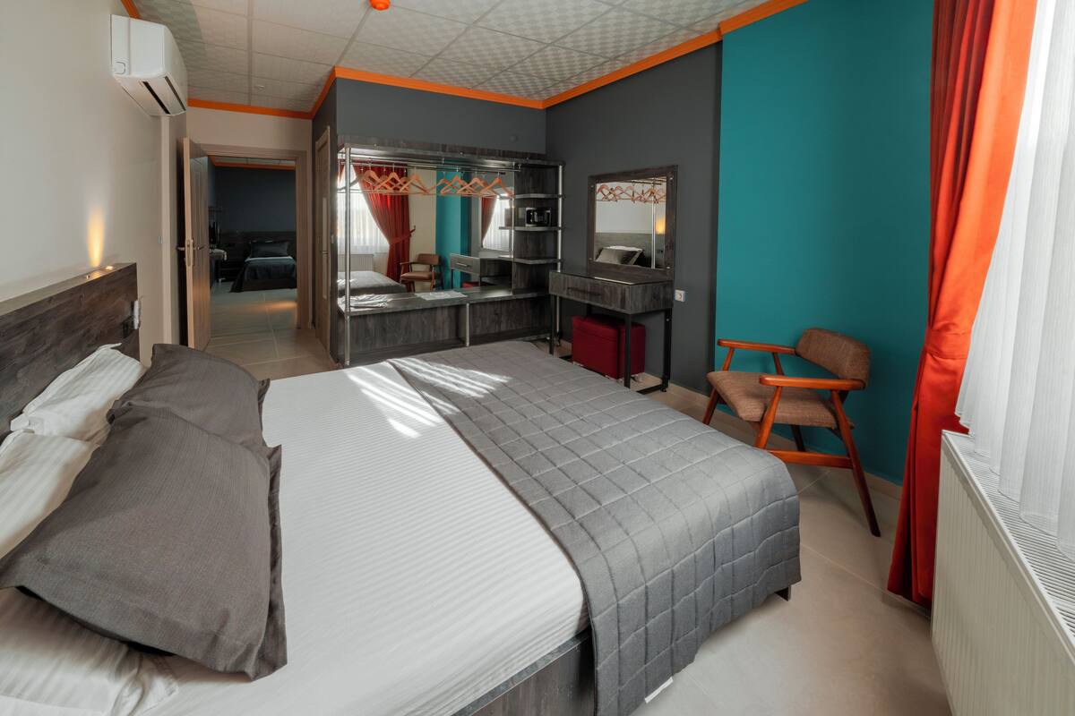 A bedroom with a bed, a desk, a chair, and a wardrobe.