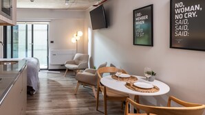 Una cocina moderna con comedor, televisor de pantalla plana y carteles motivacionales en las paredes.