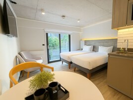 Una habitación de hotel moderna con cama, escritorio, silla, televisor y baño.