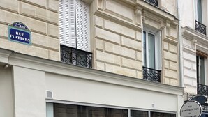 Um edifício com uma placa que diz "RUE FLATTERS" e uma placa com a inscrição "FIN D'INTERDICTION DE STATIONNER".