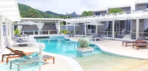 A pool area with lounge chairs, umbrellas, and a decorative vase.