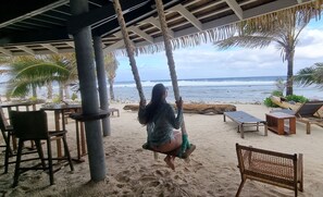 A beachside swing set with a view of the ocean.